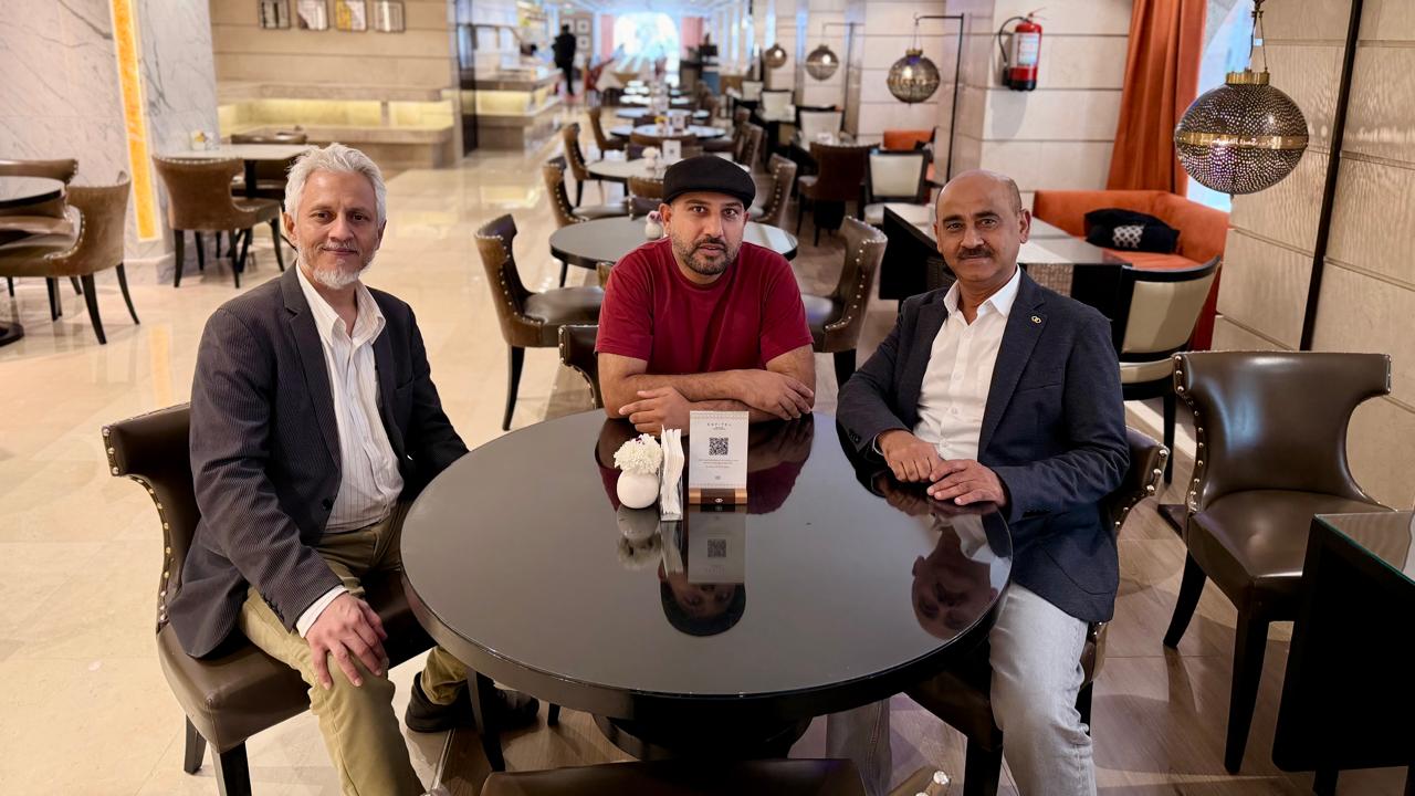 Mohsin Tutla seated at a table with two colleagues in a hotel lounge