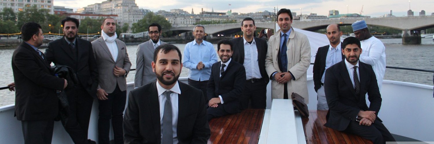 Mohsin Tutla and a group of delegates on a boat on the River Thames in London at dusk