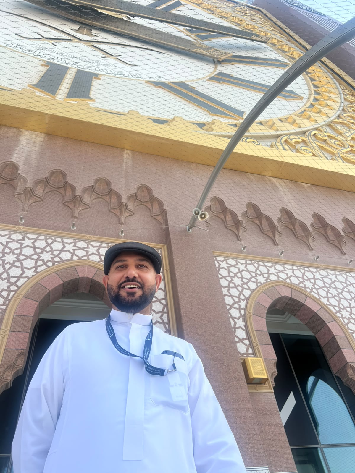 Mohsin Tutla standing beneath the Makkah Clock Tower's clock face